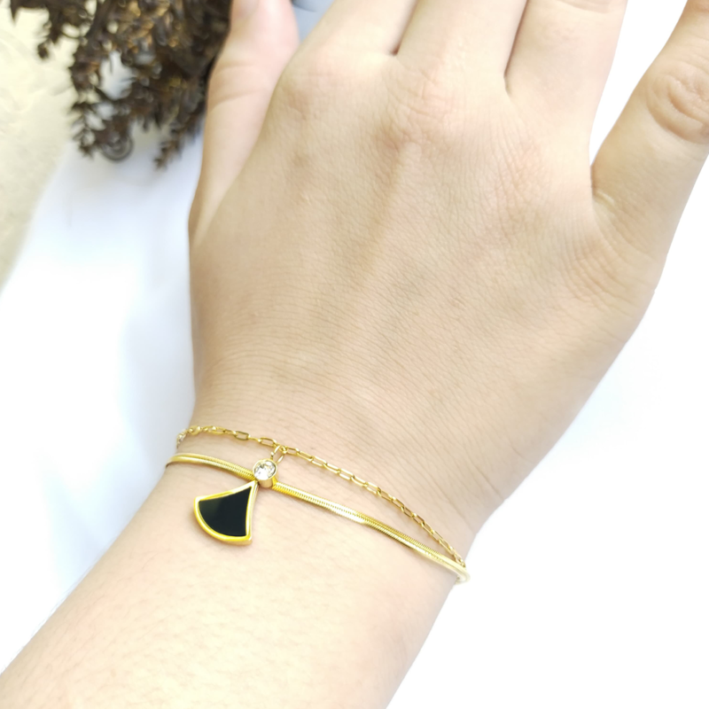 Elegant gold bracelet with black enamel charm and crystal