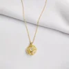 Elegant gold pendant with intricate spinning design and crystal.