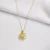 Elegant gold pendant with intricate spinning design and crystal.