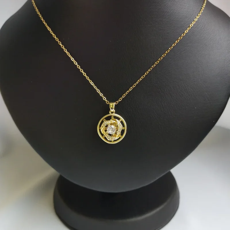 Elegant gold pendant with intricate spinning design and crystal.